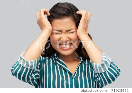 stressed asian woman holding to her head 71923451