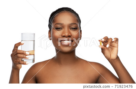 african woman with cod liver oil and water glass 71923476
