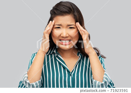stressed asian woman holding to her head stressed asian woman holding to her head 71923591