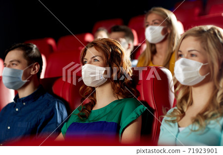 people in masks watching movie in theater people in masks watching movie in theater 71923901