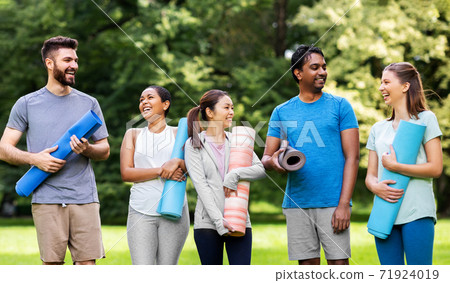 group of happy people with yoga mats at park group of happy people with yoga mats at park 71924019