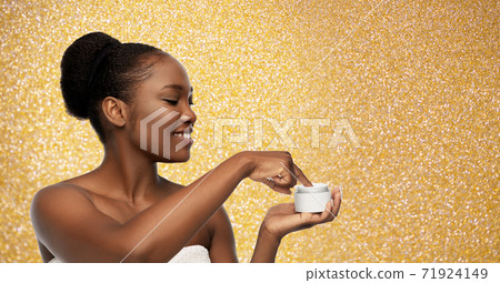 smiling african american woman with moisturizer smiling african american woman with moisturizer 71924149