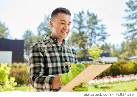 happy man with clipboard at summer garden happy man with clipboard at summer garden 71924189