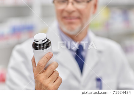 close up of pharmacist with medicine at pharmacy close up of pharmacist with medicine at pharmacy 71924484