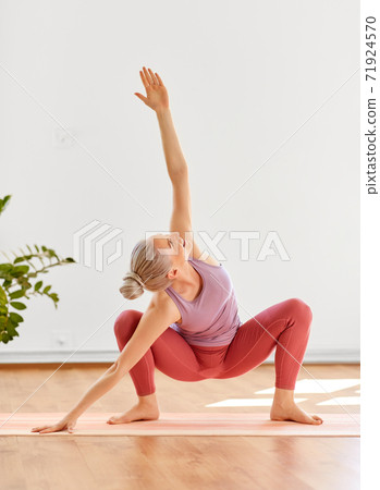 Man standing in Crescent Lunge pose in yoga studio - a Royalty Free Stock  Photo from Photocase