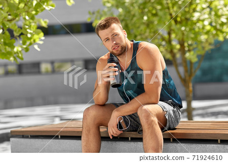 sportsman with earphones and bottle in city sportsman with earphones and bottle in city 71924610