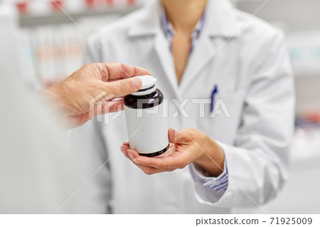 pharmacist and customer with medicine at pharmacy pharmacist and customer with medicine at pharmacy 71925009