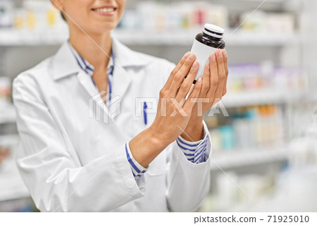 close up of pharmacist with medicine at pharmacy close up of pharmacist with medicine at pharmacy 71925010