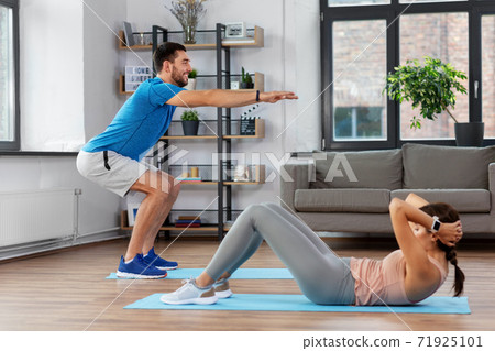 happy young man and woman exercising at home 71925101