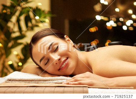 smiling woman having hot stone massage at spa smiling woman having hot stone massage at spa 71925137