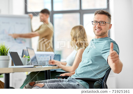 happy man in glasses showing thumbs up at office happy man in glasses showing thumbs up at office 71925161