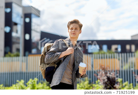 young man with backpack drinking coffee in city 71925199