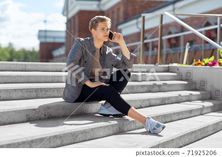 teenage boy calling on smartphone in city 71925206