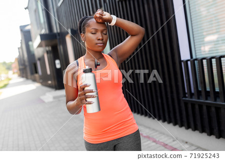 tired african american woman with bottle of water tired african american woman with bottle of water 71925243