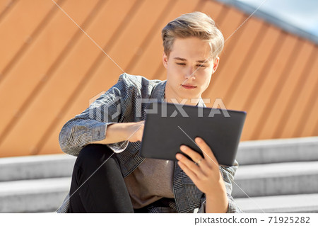 young manor teenage boy with tablet pc in city young manor teenage boy with tablet pc in city 71925282