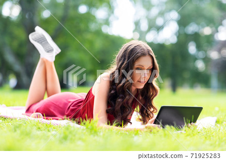 happy woman with tablet computer at park happy woman with tablet computer at park 71925283