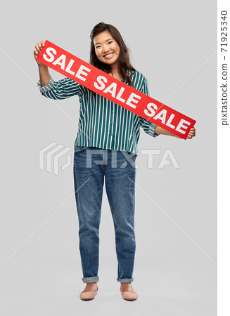 happy smiling young asian woman with sale banner happy smiling young asian woman with sale banner 71925340