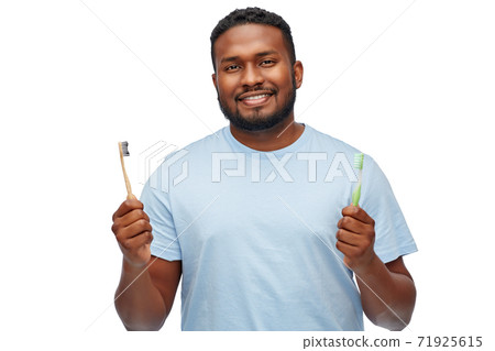 african man with wooden and plastic toothbrushes 71925615
