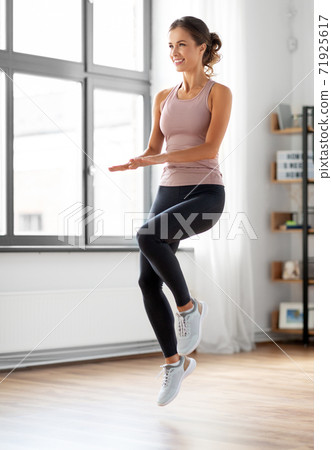 smiling young woman exercising at home smiling young woman exercising at home 71925617