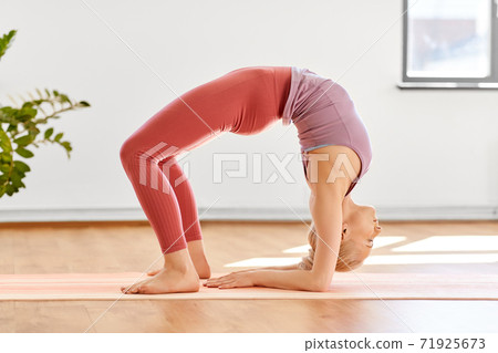 young woman doing bridge pose at yoga studio young woman doing bridge pose at yoga studio 71925673
