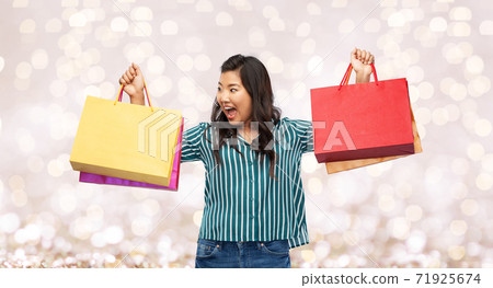 happy asian woman with shopping bags 71925674