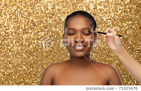 face of african woman and hand with make up brush 71925676