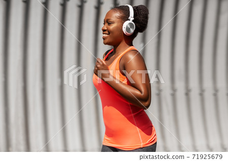 happy african american woman running outdoors 71925679