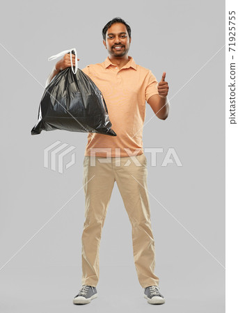 happy indian man with trash bag showing thumbs up 71925755