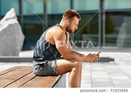 young athlete man with earphones and smartphone young athlete man with earphones and smartphone 71925868