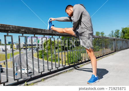 man stretching leg on bridge man stretching leg on bridge 71925871