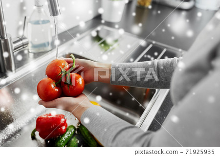 close up of woman washing vegetables in kitchen close up of woman washing vegetables in kitchen 71925935
