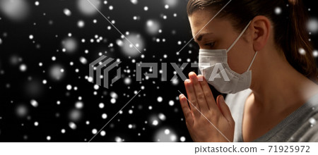 sick young woman in protective face mask praying sick young woman in protective face mask praying 71925972