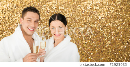 happy couple in spa bath robes drinking champagne happy couple in spa bath robes drinking champagne 71925983