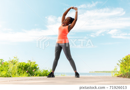 young african american woman exercising on beach young african american woman exercising on beach 71926013