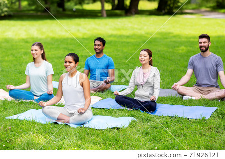 group of happy people doing yoga at summer park group of happy people doing yoga at summer park 71926121