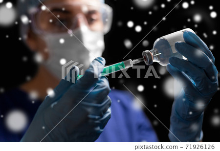 doctor in face mask with syringe and medicine doctor in face mask with syringe and medicine 71926126