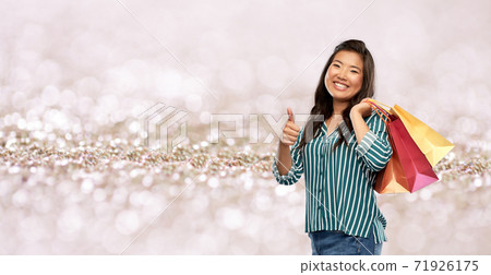 asian woman with shopping bags showing thumbs up asian woman with shopping bags showing thumbs up 71926175