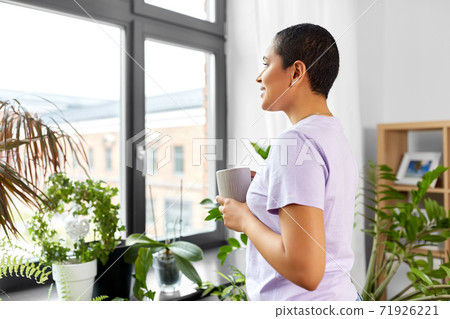 woman with coffee looking out window 71926221