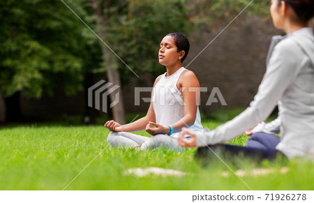 group of people doing yoga at summer park group of people doing yoga at summer park 71926278