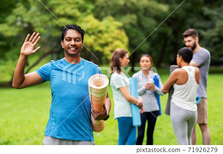 smiling man with yoga mat over group of people smiling man with yoga mat over group of people 71926279