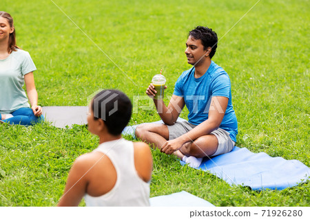 group of people sitting on yoga mats at park group of people sitting on yoga mats at park 71926280