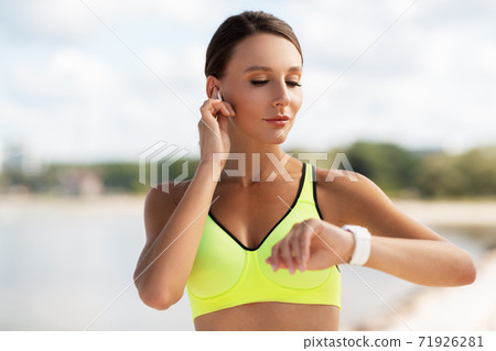 woman with earphones and smart watch doing sports woman with earphones and smart watch doing sports 71926281