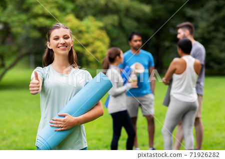 smiling woman with yoga mat showing thumbs up smiling woman with yoga mat showing thumbs up 71926282