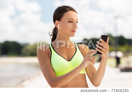 woman with earphones and smartphone doing sports woman with earphones and smartphone doing sports 71926285