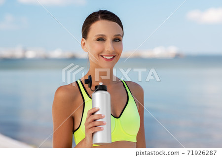 woman drinking water from bottle after sports woman drinking water from bottle after sports 71926287