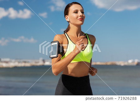 woman with earphones and smartphone running woman with earphones and smartphone running 71926288