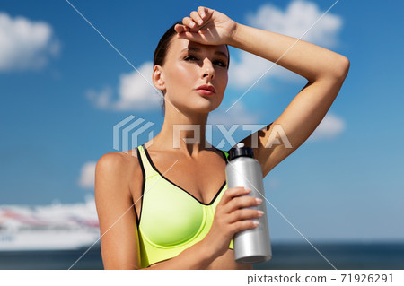 woman drinking water from bottle after sports woman drinking water from bottle after sports 71926291