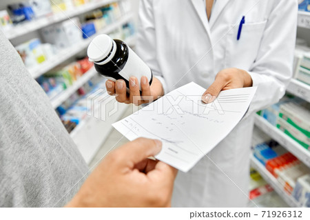 pharmacist and customer with medicine at pharmacy pharmacist and customer with medicine at pharmacy 71926312