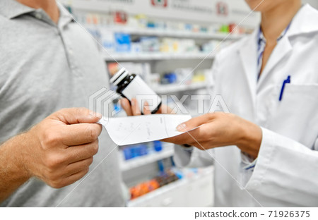 pharmacist and customer with medicine at pharmacy pharmacist and customer with medicine at pharmacy 71926375