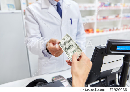 pharmacist taking money from customer at pharmacy pharmacist taking money from customer at pharmacy 71926688
